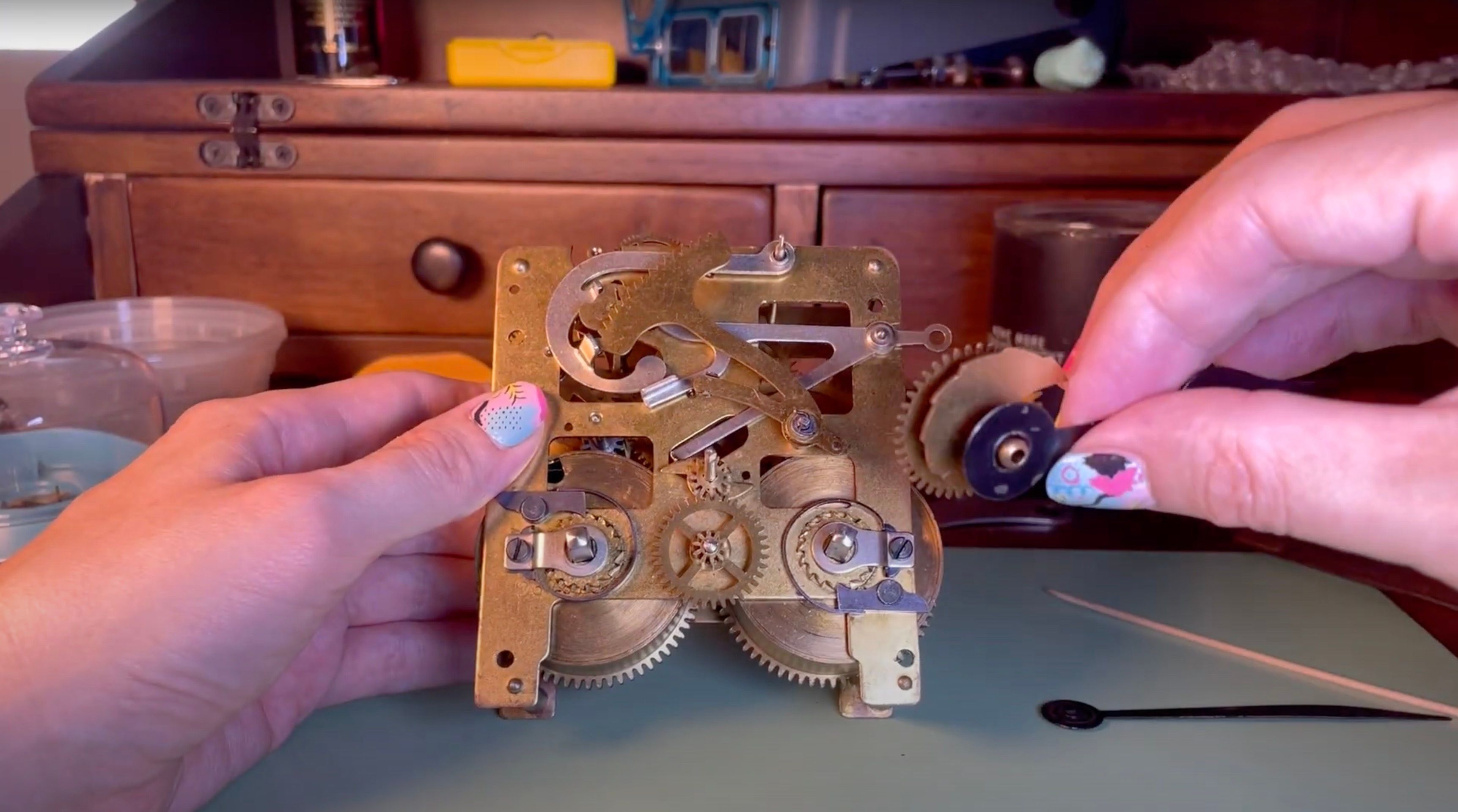 First-person Miriam holding the internal motionworks of a mechanical clock
